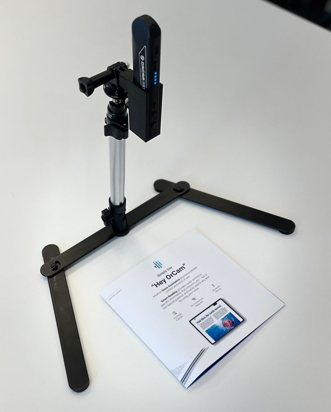 OrCam stand holding OrCam Read, freestanding and positioned above the reading material
